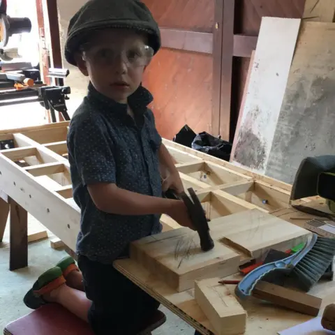 Emma Eltham Alfie, aged four, with a toy drill in a workshop.