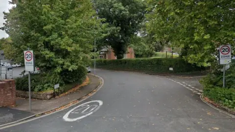 A street view image of Clifton Road in Exeter. It has 20mph signs and writing on the road. 