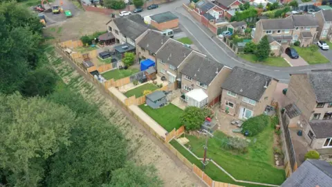 Department for Environment, Food and Rural Affairs An aerial image featuring Toronto Close, showing houses, gardens, a road and trees