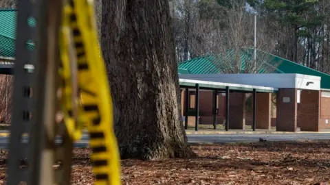 Getty Images Police tape hangs from a sign post outside Richneck Elementary School following a shooting on January 7, 2023 in Newport News, Virginia