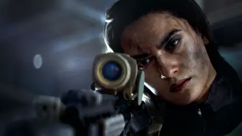 Electronic Arts A screenshot from Battlefield 6 shows a close-up of a female character in combat fatigues looking down the scope of a high-powered rifle. She wears a look of concentration as she focuses on a distant target.