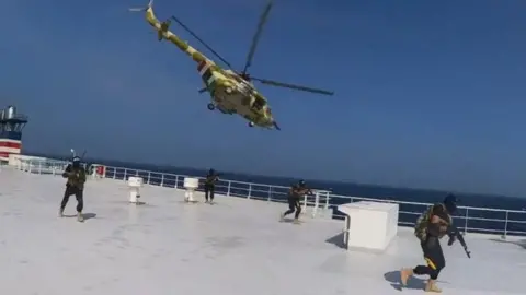 Houthi military helicopter hovers over the Galaxy Leader cargo ship in Red Sea in November 2023