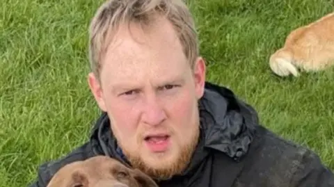 Rhys Jamieson hugging a dog