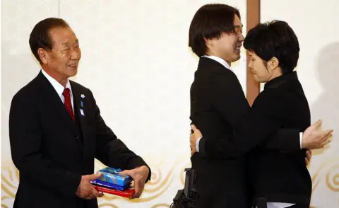 Korea pool/Getty Images Shigeo Iizuka looks on as Koichiro Iizuka, son of the abductee Yaeko Taguchi, hugs former North Korean spy Kim Hyun-hui before a press conference on March 11, 2009 in Busan, South Korea.