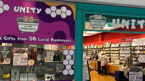 Dave Poulton Exterior of the Unity store - with a purple and green frontage.