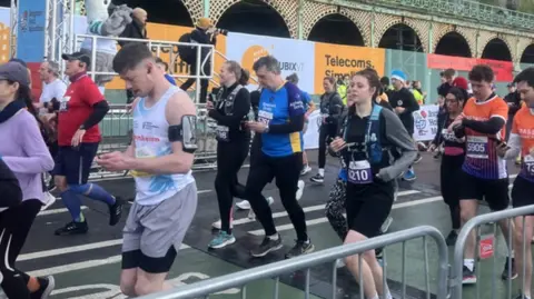 A number of runners undertaking the Brighton Half Marathon down at the seafront.