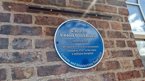 University of Cumbria The blue plaque on the side of the Skiddaw building, commemorating its role as a workhouse, deigned to house 478 people