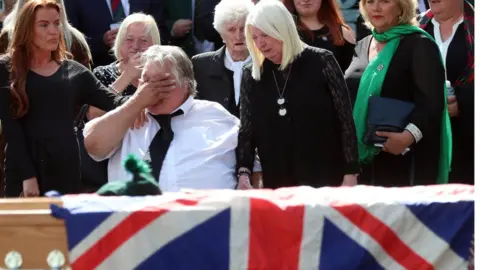 Pacemaker Brett Savage's parents, pictured at his funeral on Friday, say they are "utterly heartbroken"