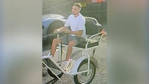 Image of a man sitting on a horse trap on a road in Newark, Nottinghamshire.
