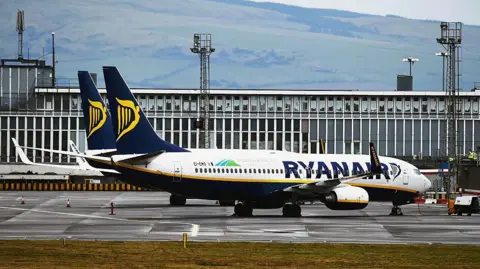 Getty Images Two white and navy blue Ryanair planes parked at Prestwick Airport.