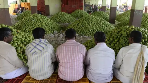 Getty Images Representational photo: Indian farmers wait for mangoes to be auctioned at the Gaddiannaram fruit market on the outskirts of Hyderabad on April 30, 2018.