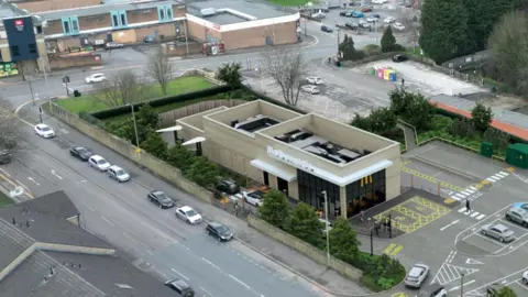 LDRS An artist's impression of how the McDonald's in Bingley could look, with a restaurant building superimposed onto a photograph of the area with a car park and streets around it