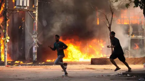 According to reports, Getty Images, a clothing store, is burned by a group of unidentified criminals in Dhaka on August 4, 2024. 