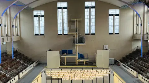 Artwork inside art deco swimming pool, words are lit up.