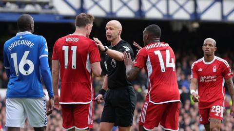 Referee Anthony Taylor speaks with Nottingham Forest players