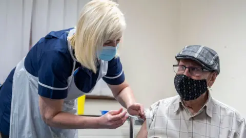 Getty Images One of the early people to get a first dose of a vaccine in Merthyr Tydfil