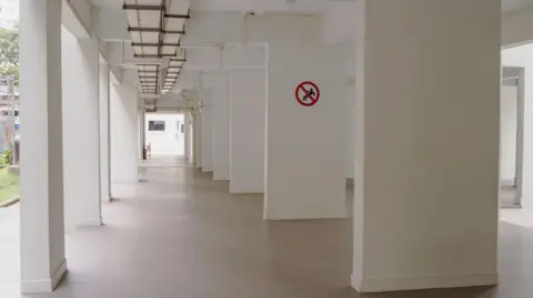 Getty Images An empty space under a Singapore public housing block. There's a sign on the wall showing that ball games are banned