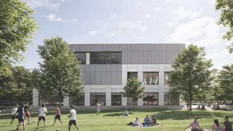 FaulknerBrowns A view of a three-storey building from one side. It has large glass windows throughout the ground floor and half way across the second and third floors. There are people playing in a park in the foreground while others sit on blankets on the grass.