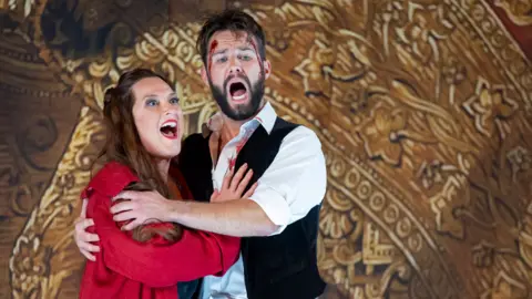 Getty Images Sinead Campbell-Wallace as Floria Tosca and Adam Smith as Matio Scarpia perform onstage during a production of Tosca by Giacmo Puccini at London Coliseum on September 28, 2022 in London, England.