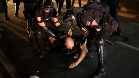 Os policiais da Reuters detêm um manifestante, durante um protesto antigovernamental exigindo eleições instantâneas, em Belgrado