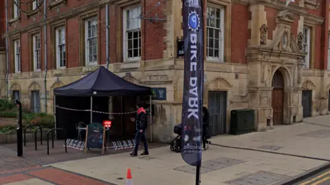 The canopy and sign of the bike park outside Leicester Town Hall