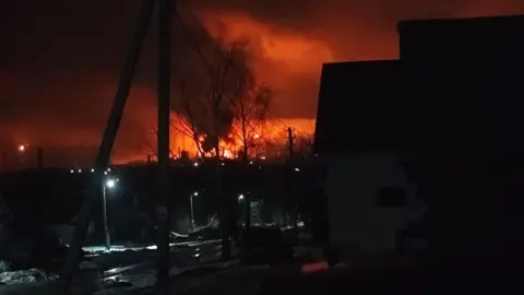 A photo of a dark night sky lit up by red flames