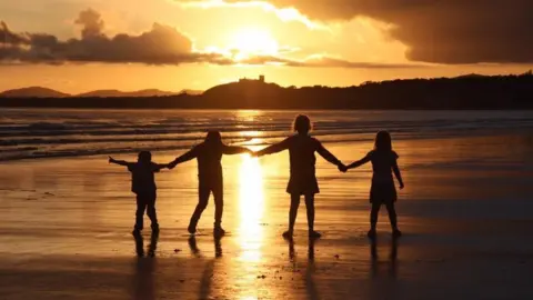 Alexandra Nash  Sunset beach: Alexandra Nash's spectacular view of children holding hands at Black Rock Sands, Gwynedd