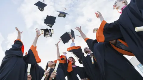 Getty Images Stock picture of university graduates throwing mortar boards in the air