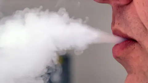 PA Media A man breathing out smoke