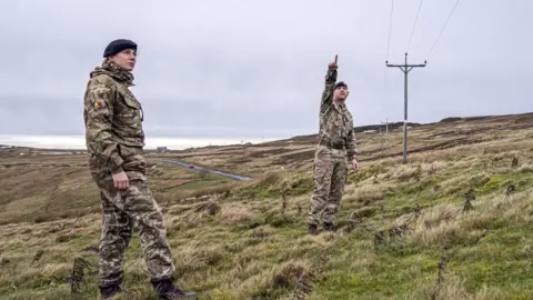 PA Media Members of the armed forces check on overhead power cables in Weardale, County Durham