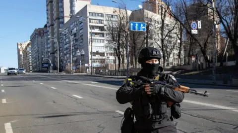 Getty Images Police officer standS guard at a checkpoint on February 28, 2022 in Kyiv