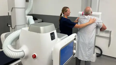 Peter Moult prepares to have a chest X-ray at Coalville Community Hospital