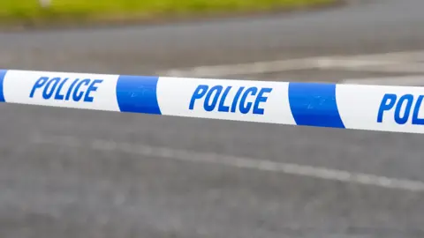 A close-up of a police tape on a road 