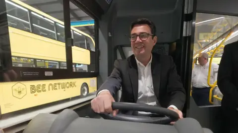 PA Media Greater Manchester mayor Andy Burnham sits in a new "Bee Network" bus