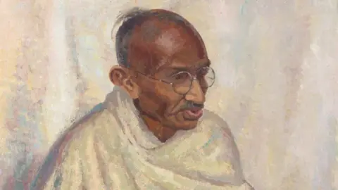 An oil painting of Mahatma Gandhi where he has a white cloth draped around his torso and is wearing round glasses 