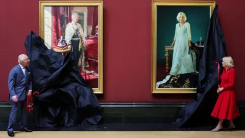 King Charles and Queen Camilla removing covers from portraits depicting them