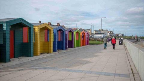 A row of multi-coloured beach huts
