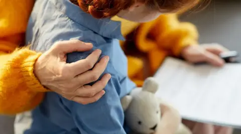 Getty Images A child with an arm on its shoulder