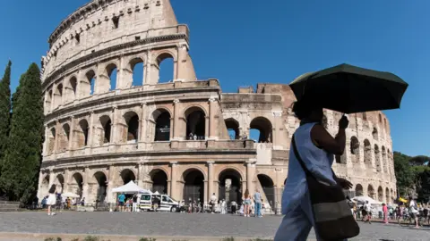 Tourists visit the Colosseum as the heatwave is in progress in Rome, Italy.