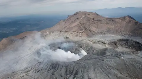 White smoke billows out of crater of massive volcano