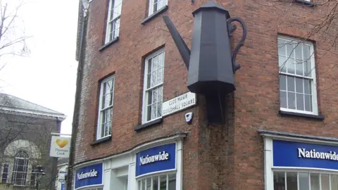 A giant 19th Century coffee pot on the side of a town building in Carmarthen town centre