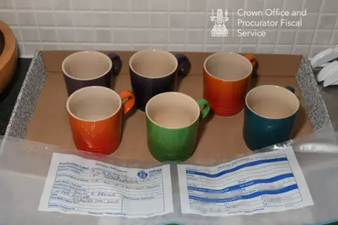 COPFS Le Creuset mugs on the kitchen counter. They are different colours.