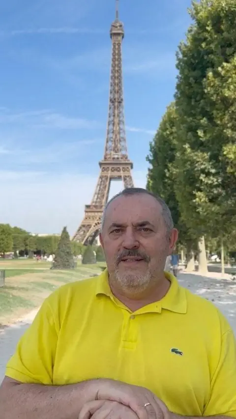 Reuters Boris Nadezhdin wears a yellow Lacoste polo shirt while standing in front of the Eiffel Tower on a sunny day in Paris, in this still image from a video released on his Telegram.