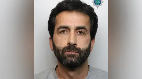 Staffordshire Police Police photo of a man with a dark beard and short black hair.