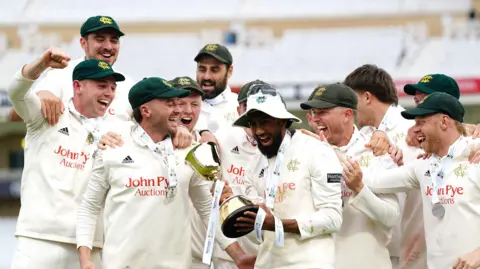 Nottinghamshire players lift the County Championship trophy