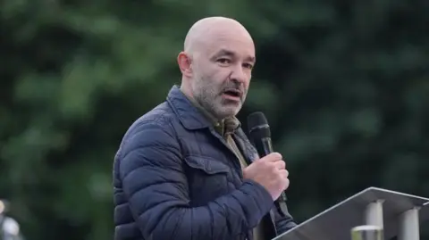 PA Media File photo dated 14/06/24 of Marcio Gomes of Grenfell United speaking on stage following a silent walk near Grenfell Tower in London in remembrance of those who died in the Grenfell Tower fire on June 14 2017. A new documentary into the Grenfell fire setting out the failings which led to the fatal blaze must mark a "turning point" in the fight for justice, a grieving father featured in it has said. Issue date: Monday June 16, 2025.
