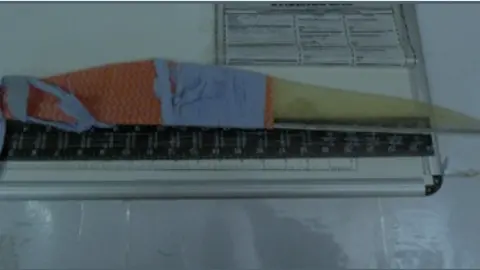HM Inspectorate of Prisons A makeshift weapon with blue cloth wrapped around one end. It is placed next to a ruler indicating how long it is.