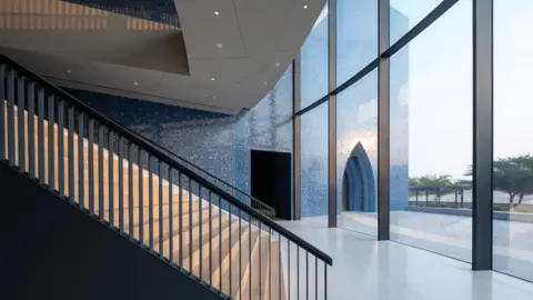 Qatar Foundation Light reflects off the blue tiles of the  Lawh Wa Qalam museum and falls on a staircase