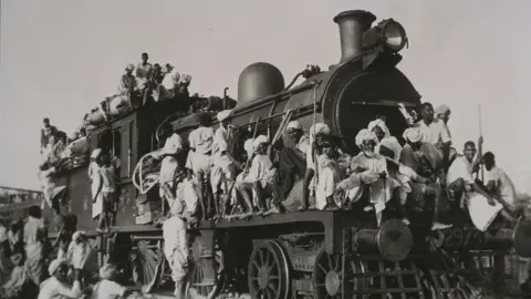 Getty Images Muslim refugees fleeing India for Pakistan crowd train engine, 1947. Gelatin silver photograph shows Muslim refugees fleeing India for Pakistan. They are crowding the train engine in their panic and desperation to leave the country. (Photo by Daily Herald Archive/National Science & Media Museum/SSPL via Getty Images)
