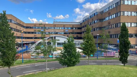 Image of the outside of the Queen's Medical Centre, a large, 1970s four storey building